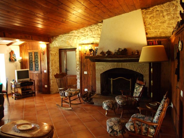 Un soggiorno accogliente in stile rustico, con un camino funzionante e mobili comodi.