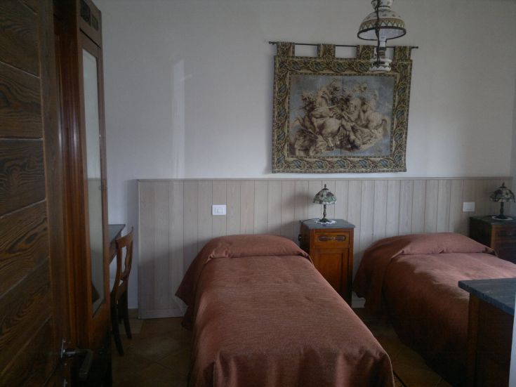 Camera semplice con letti singoli, decorazioni sobrie e un ambiente tranquillo.