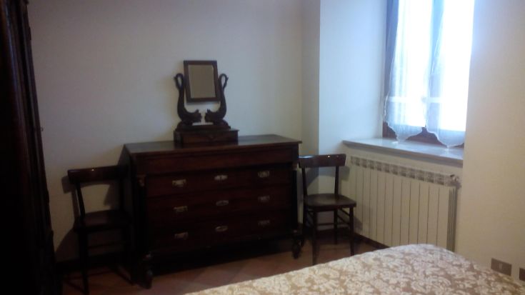 Spazio luminoso con arredi in legno e tocchi di design classico, ideale per rilassarsi.