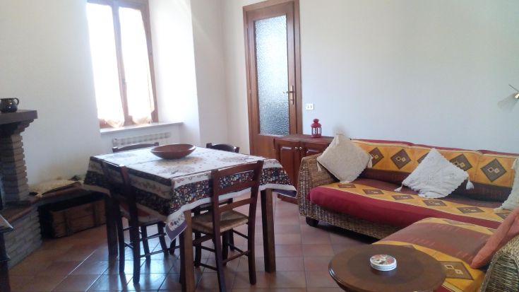 Spazio accogliente con tavolo da pranzo e divano, ideale per famiglie o piccoli gruppi di amici.