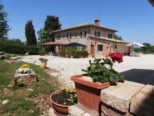 Rustic farmhouse in Umbria, surrounded by greenery, with apartments and a double room, offering tranquility in nature.