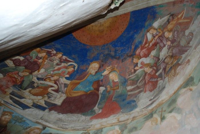 Un affresco che mostra una scena religiosa con figure angeliche e personaggi legati alla fede.