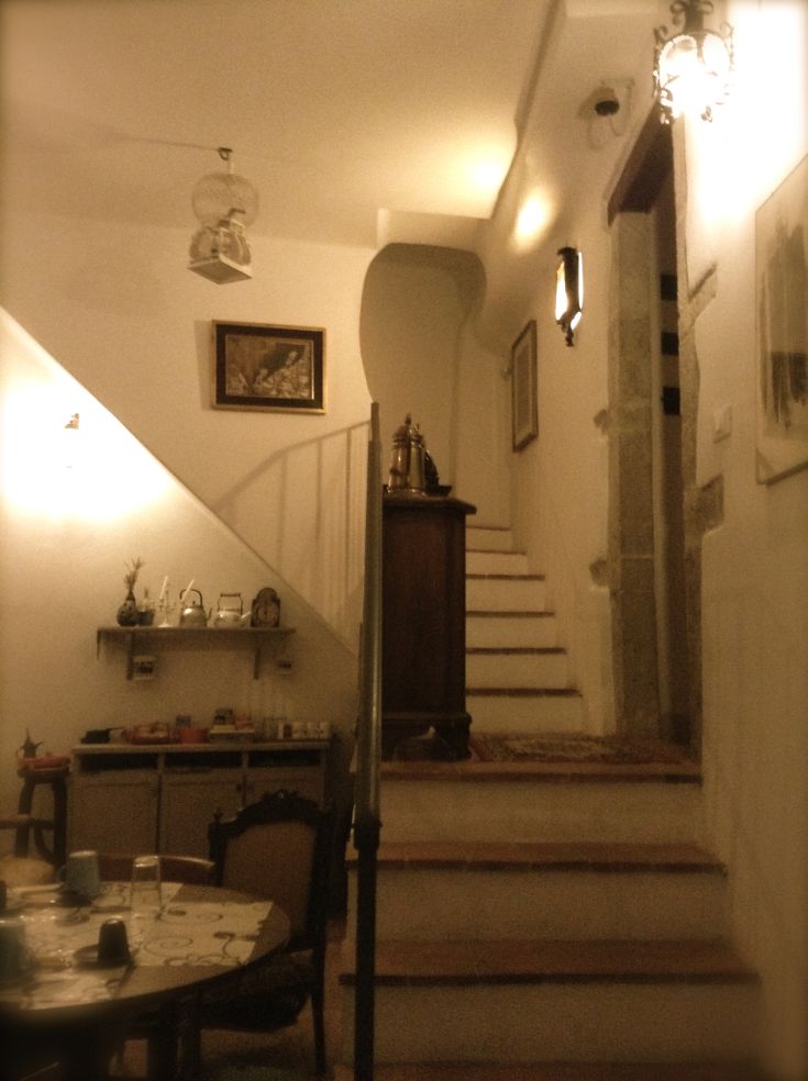 Interno di una casa storica con scale ampie, soffitti alti e alcuni elementi decorativi.