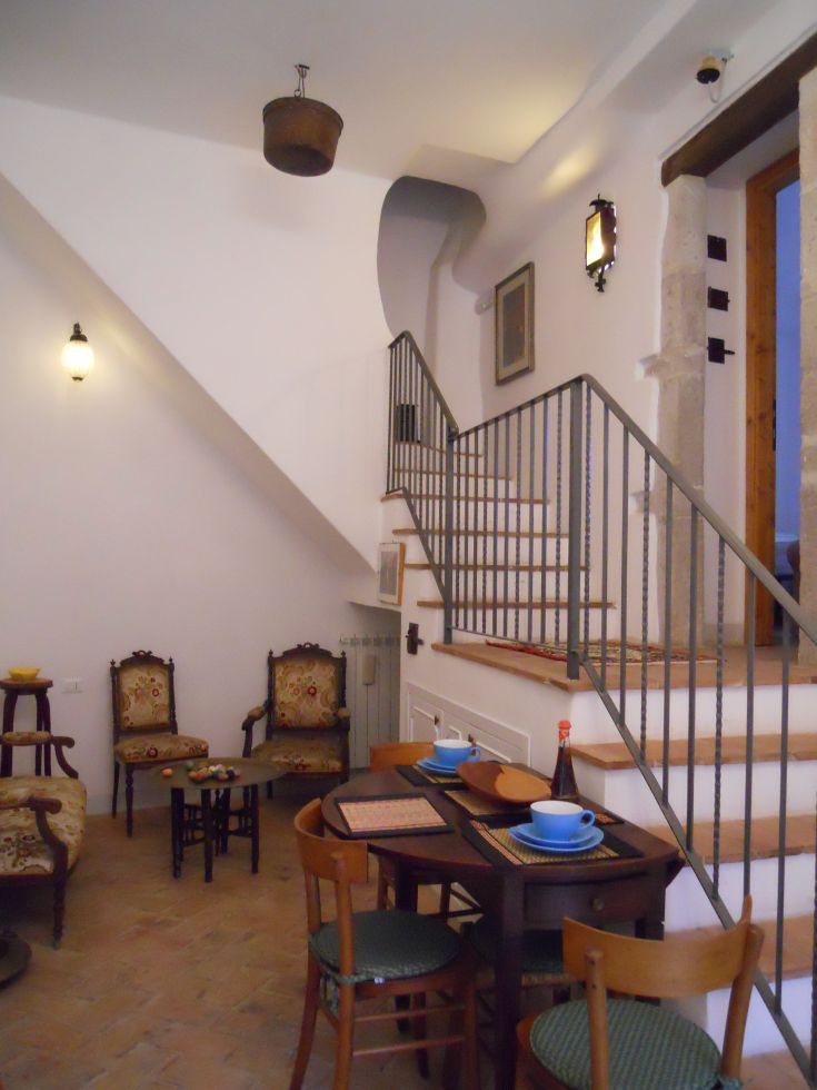 Ambiente semplice di una guesthouse con arredi classici e uno spazio interno ben illuminato.