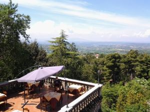 Un'osteria accogliente con panorama su un paesaggio collinare verdeggiante.