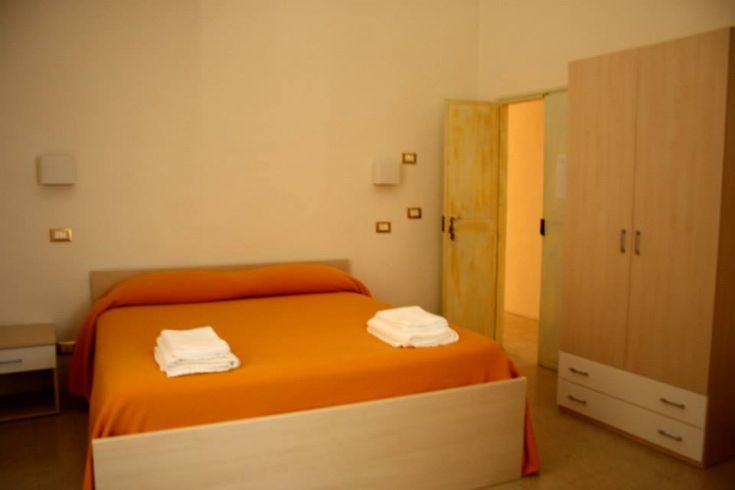 Camera accogliente con un letto matrimoniale e arredi essenziali.