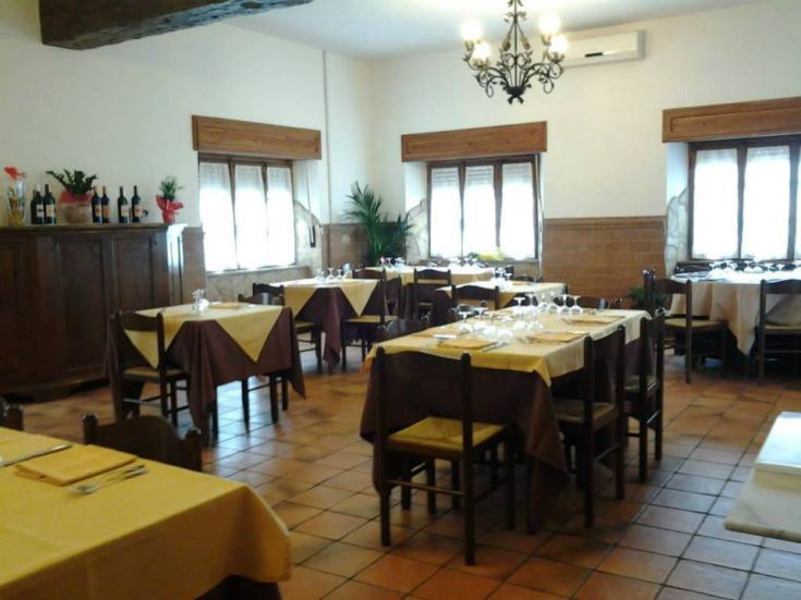 Interno semplice di un ristorante con tavoli ordinati e una piacevole atmosfera.