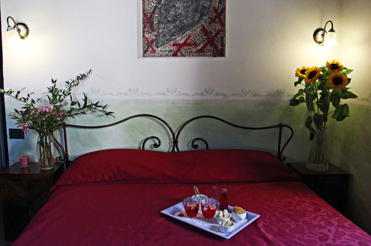 A simple room featuring a red bed and floral decorations, ideal for a peaceful stay.