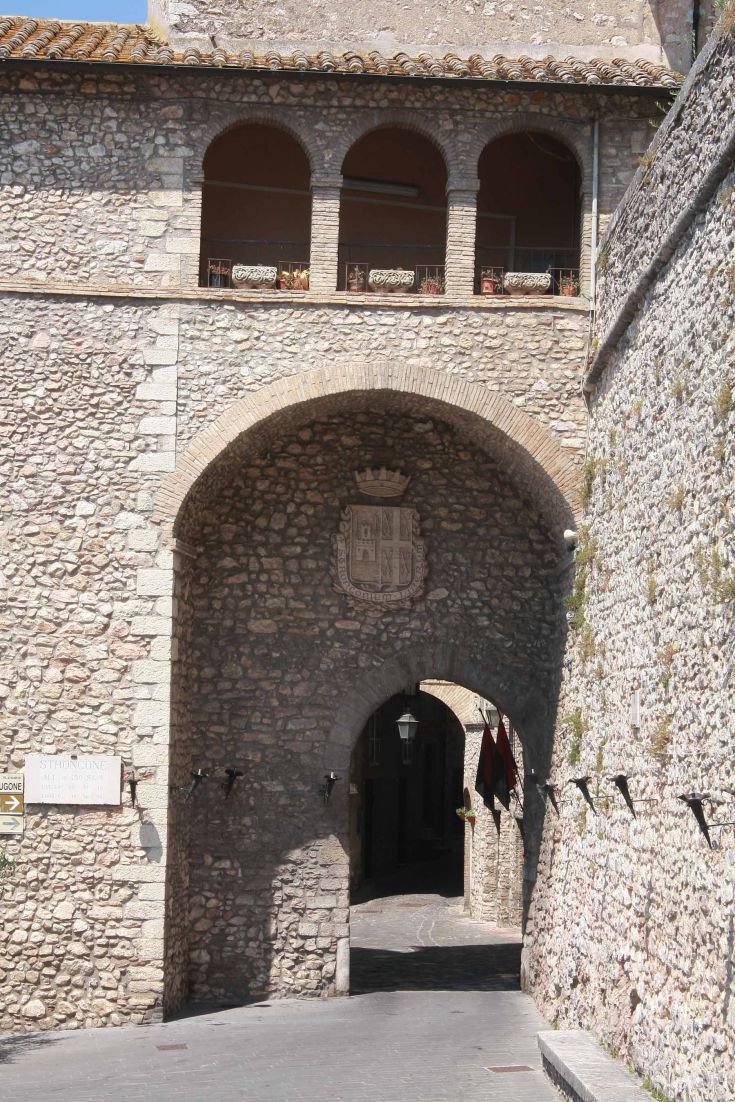 Entrance door of a historic building in an Umbrian village, showcasing architectural elements.