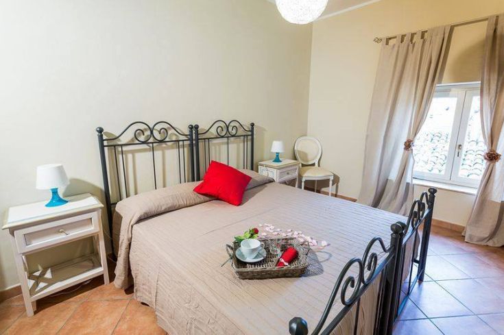 A simple bedroom with a double bed and well-kept decorative elements, in a serene atmosphere.