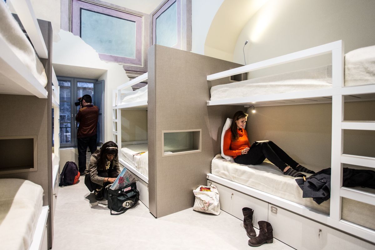 Interno di un grande edificio con diverse stanze adibite a camere da letto, adatte per un soggiorno condiviso.