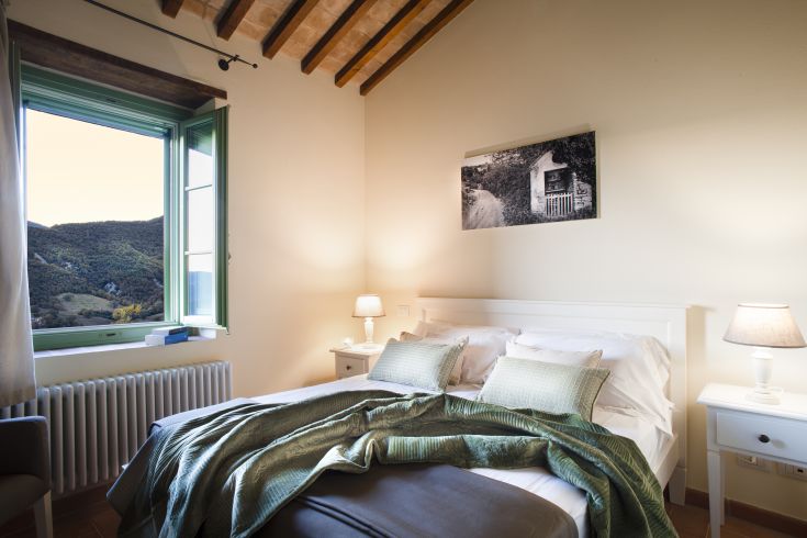 Cozy room with a view of the Umbrian hills, comfortable beds, and simple decor.