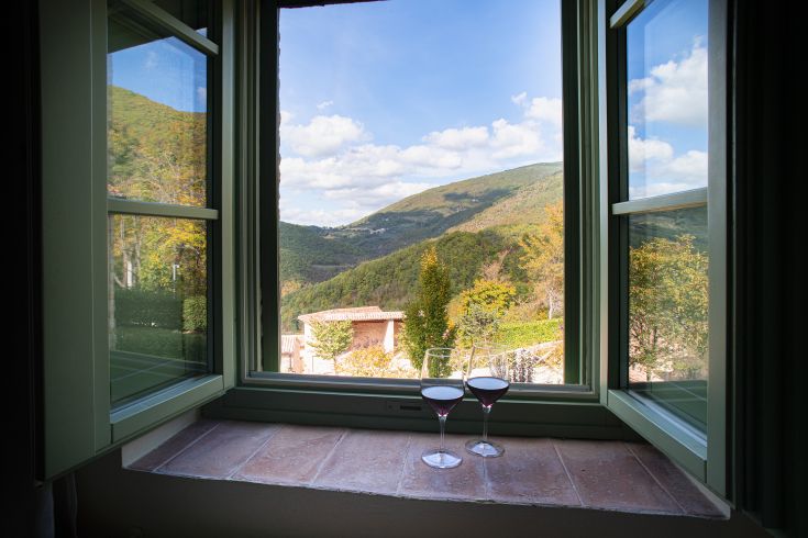 Scena tranquilla con calici di vino, circondati dal verde della natura umbra.