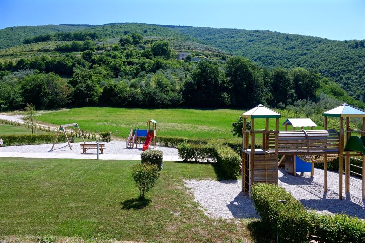 Un'area giochi circondata da spazi verdi, adatta per famiglie e bambini.