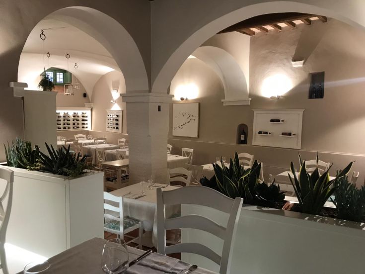 Un ristorante accogliente con dettagli in stile classico e una selezione di vini ben visibile.