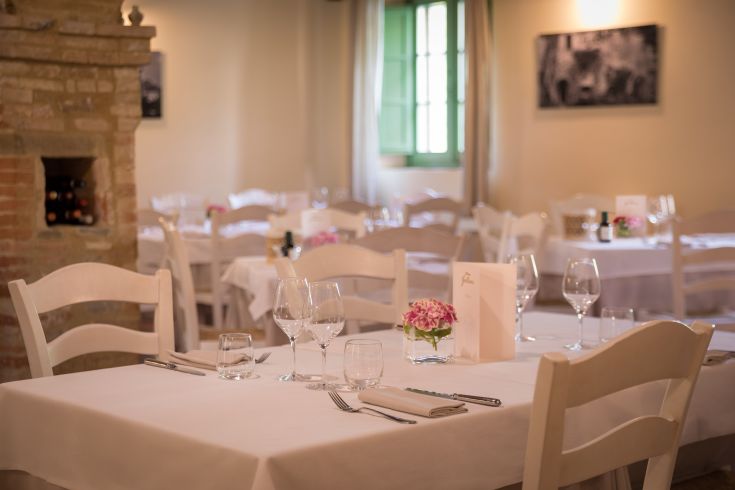 Un ristorante con tavoli ben sistemati e decorazioni floreali, ambiente piacevole e luminoso.