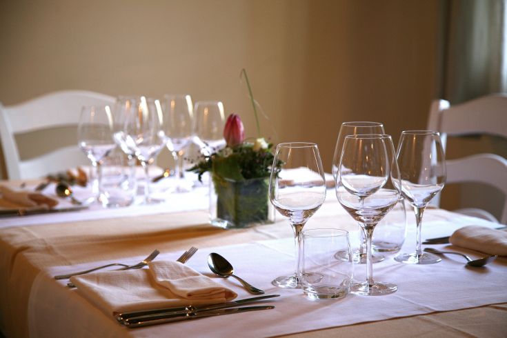 A beautifully set table adorned with glasses and floral decorations, ready for a special occasion.