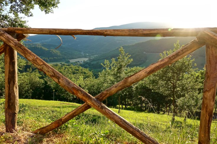 A mountain scenery framed by a wooden fence.