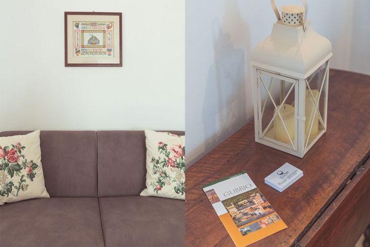 Soggiorno con cuscini decorati e lanternina vintage. Dettagli di arredo in un agriturismo in Umbria.