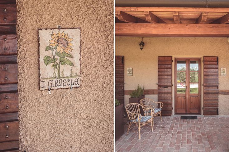 Facciata di un edificio con un'insegna di ceramica che rappresenta un girasole.