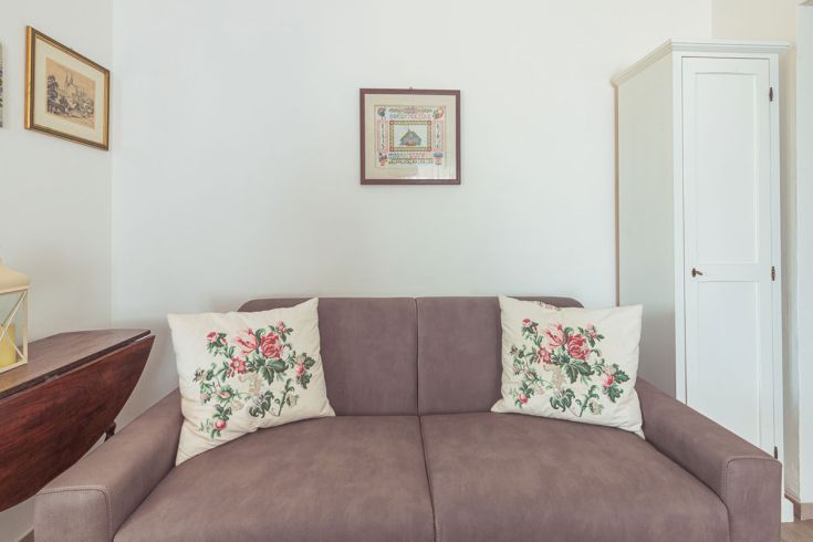 Un divano comodo con cuscini a fantasia in un ambiente luminoso e sobrio.