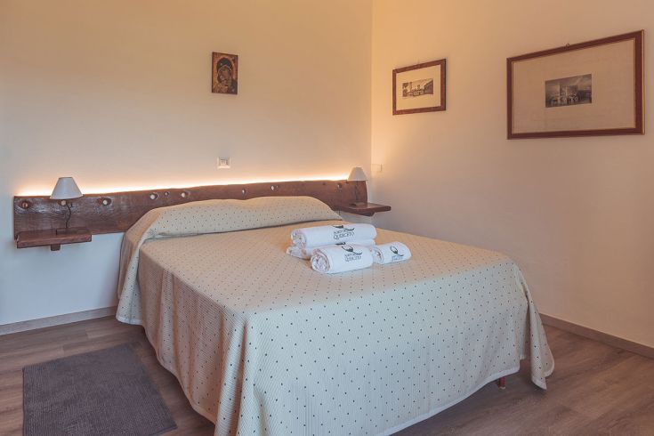 Camera semplice e confortevole con letto matrimoniale, ideale per un soggiorno immerso nella natura.