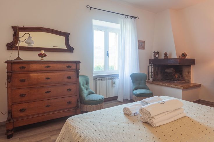 Camera semplice con mobili in legno e camino, adatta per momenti di relax.