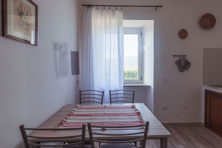 Spazioso e ben illuminato interno di un agriturismo, caratterizzato da decorazioni sobrie.