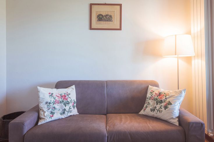 Ambiente confortevole con divano e lampada, perfetto per momenti di relax.