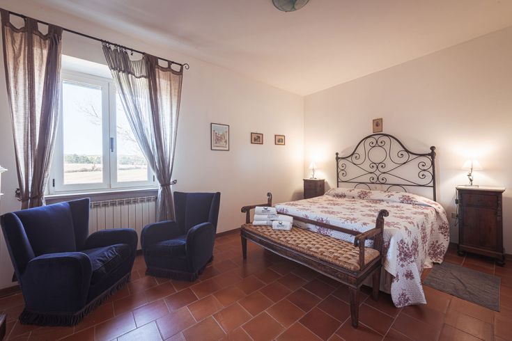 Camera accogliente con panorama sulla campagna, letti comodi e arredamento semplice.