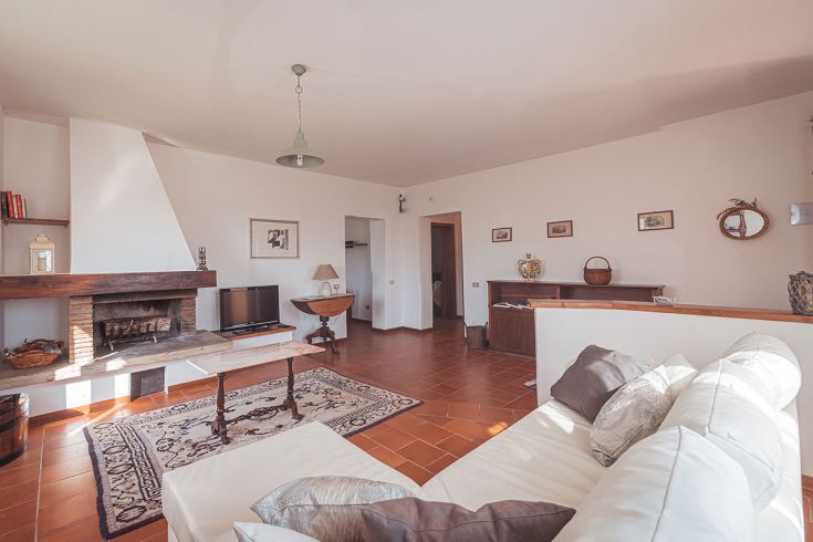 Soggiorno dell'agriturismo con camino e mobili rustici, un ambiente semplice e confortevole.