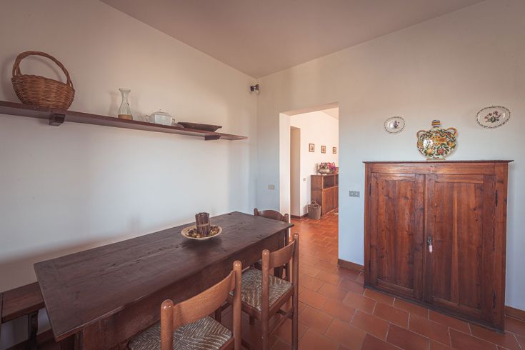 Ambiente semplice con tavolo in legno e decorazioni tradizionali.