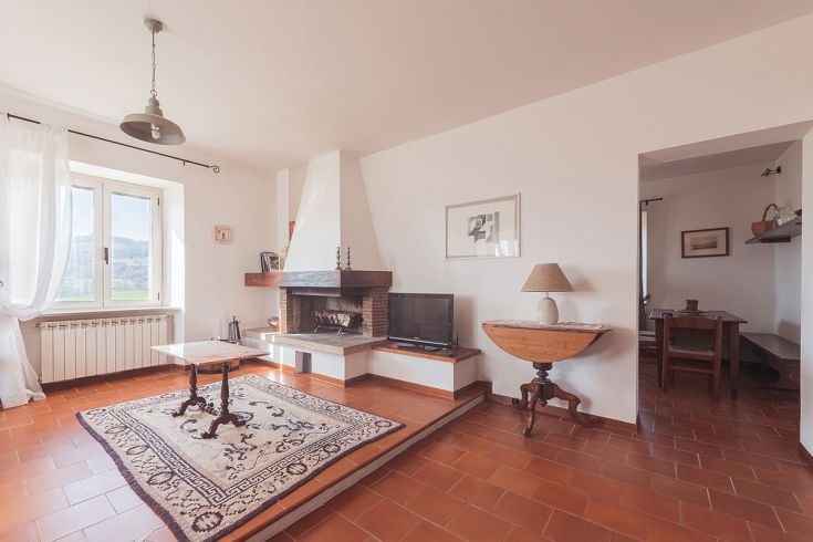 Ambiente accogliente con camino e panorama sulla campagna, perfetto per momenti di relax.