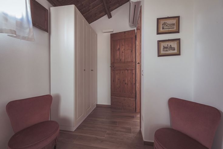 Spazio confortevole di un agriturismo con divani morbidi e armadio in legno.