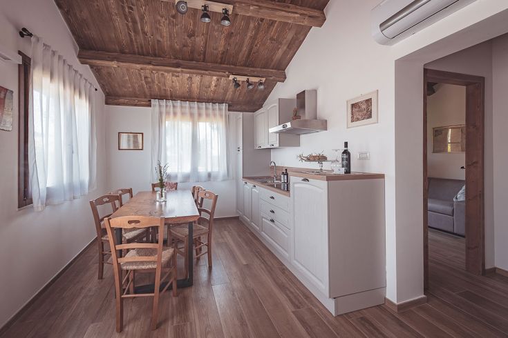 Una cucina rustica con tavolo in legno e un'atmosfera calda e ospitale.