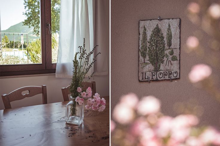 Interno semplice con fiori freschi e un dipinto che mostra il paesaggio circostante.