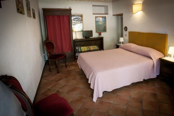 Cozy room with a double bed and wooden furnishings, perfect for a relaxing stay.