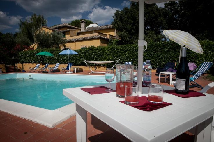 A relaxing moment by the pool, with a cocktail and a peaceful view of the Umbrian countryside.