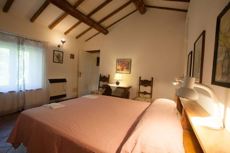 A spacious bedroom with a double bed and wooden details, perfect for relaxing moments.