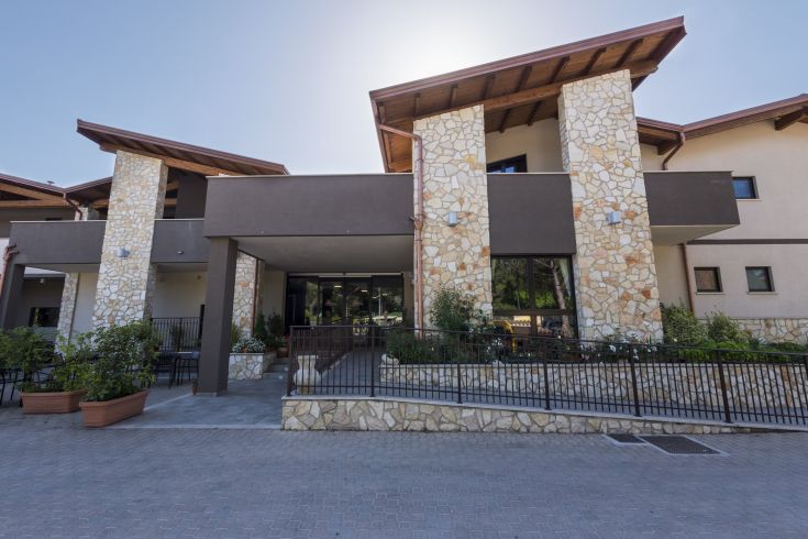 Hotel with stone and wooden architecture, featuring well-kept and cozy outdoor spaces.