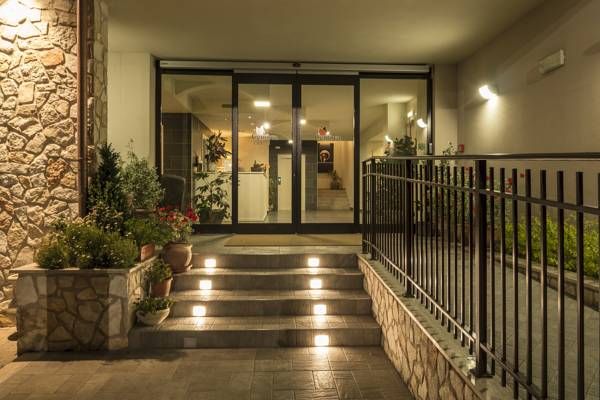 Entrance of a hotel with soft lighting and ornamental plants creating a relaxing atmosphere.
