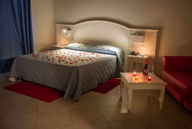 A cozy room adorned with rose petals and champagne glasses, perfect for special moments.
