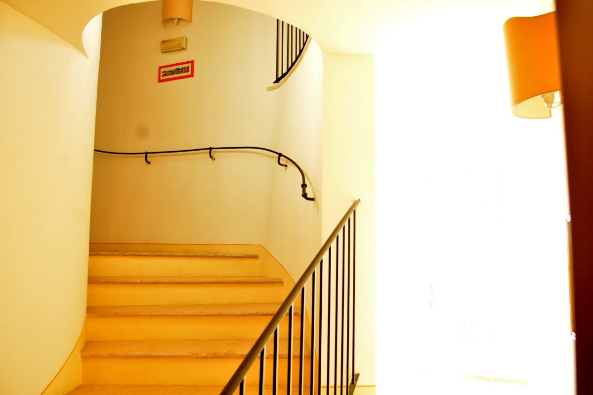 Gut beleuchtete Treppe, die zu den oberen Etagen eines einfachen und einladenden Gebäudes führt.