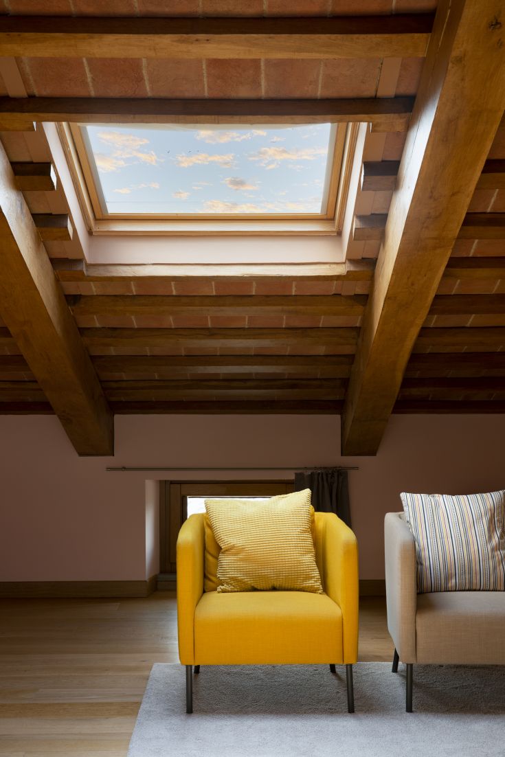 Un accogliente salotto con poltrone moderne e un'illuminazione naturale che entra dal lucernario.