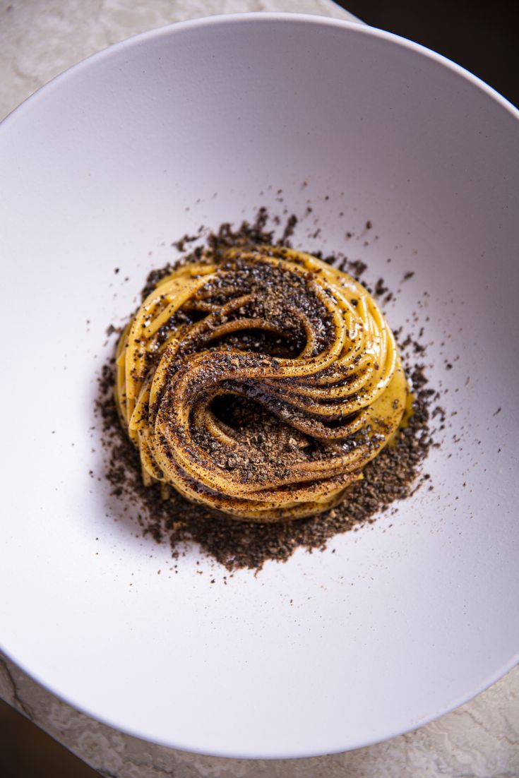 Un piatto di pasta servito con pepe nero, presentato in modo semplice ma curato. Un sapore da gustare.