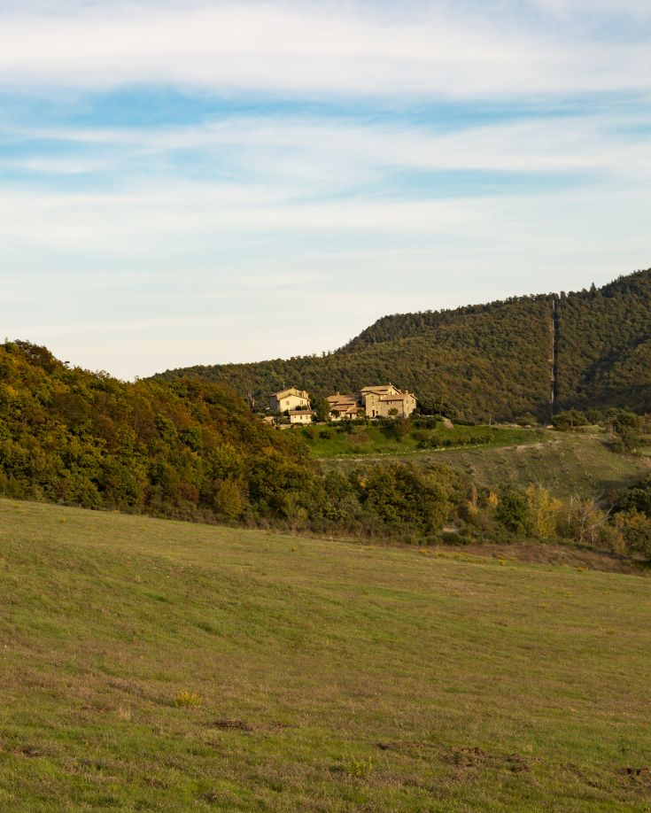 Un borgo storico circondato da alberi, ideale per una pausa tranquilla in Umbria.