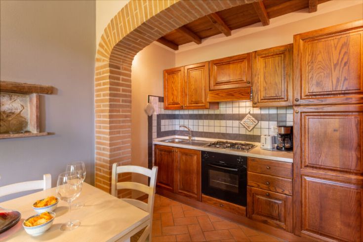 Geräumige Küche mit Holzmöbeln und Steindetails, perfekt für einen ruhigen Aufenthalt.