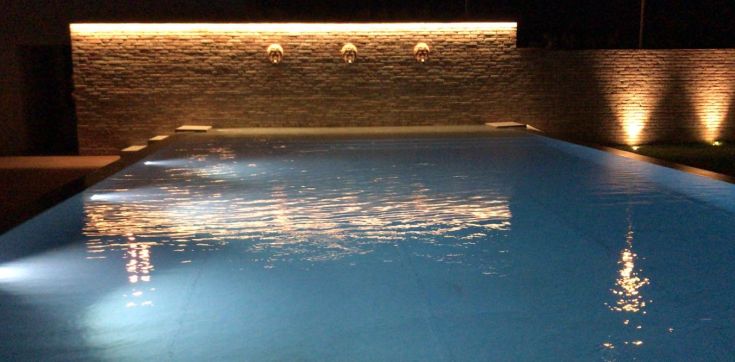 Piscina illuminata da luci morbide, creando riflessi piacevoli. Un luogo tranquillo per il relax serale.