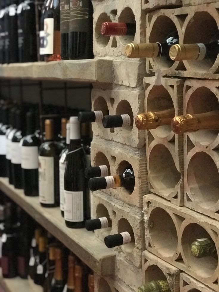 Una scelta di vini disposti su scaffali in mattoni, offrendo un ambiente intimo e piacevole.