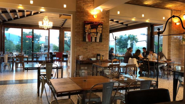 Una sala da pranzo accogliente con tavoli ben apparecchiati e un panorama sul verde circostante.